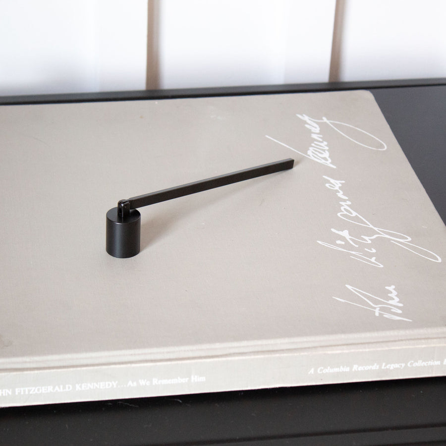 Black candle snuffer on a ook