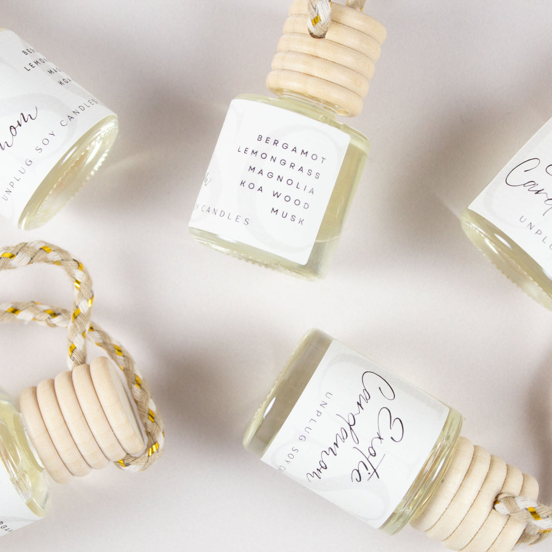 Five small bottles with wooden caps and white labels on a light background