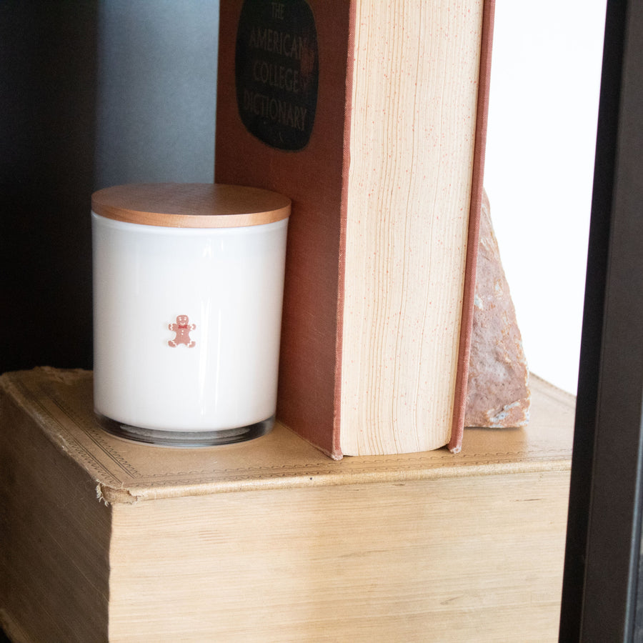 White candle with wooden lid on a stack of books