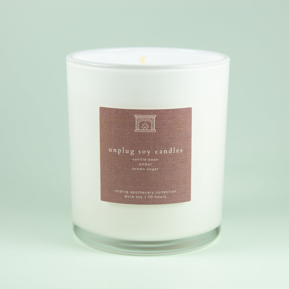 White spy candle with a light brown label on a light green background