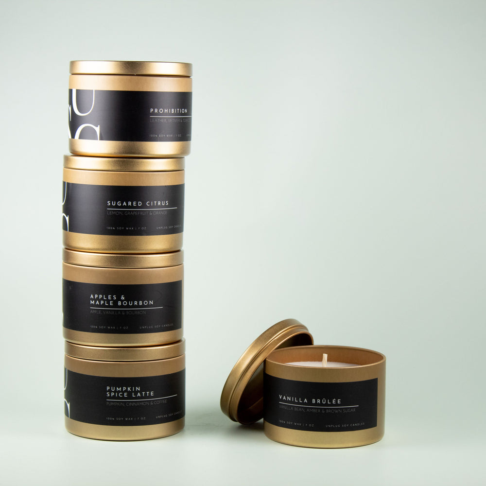 Stack of gold tin soy candles 